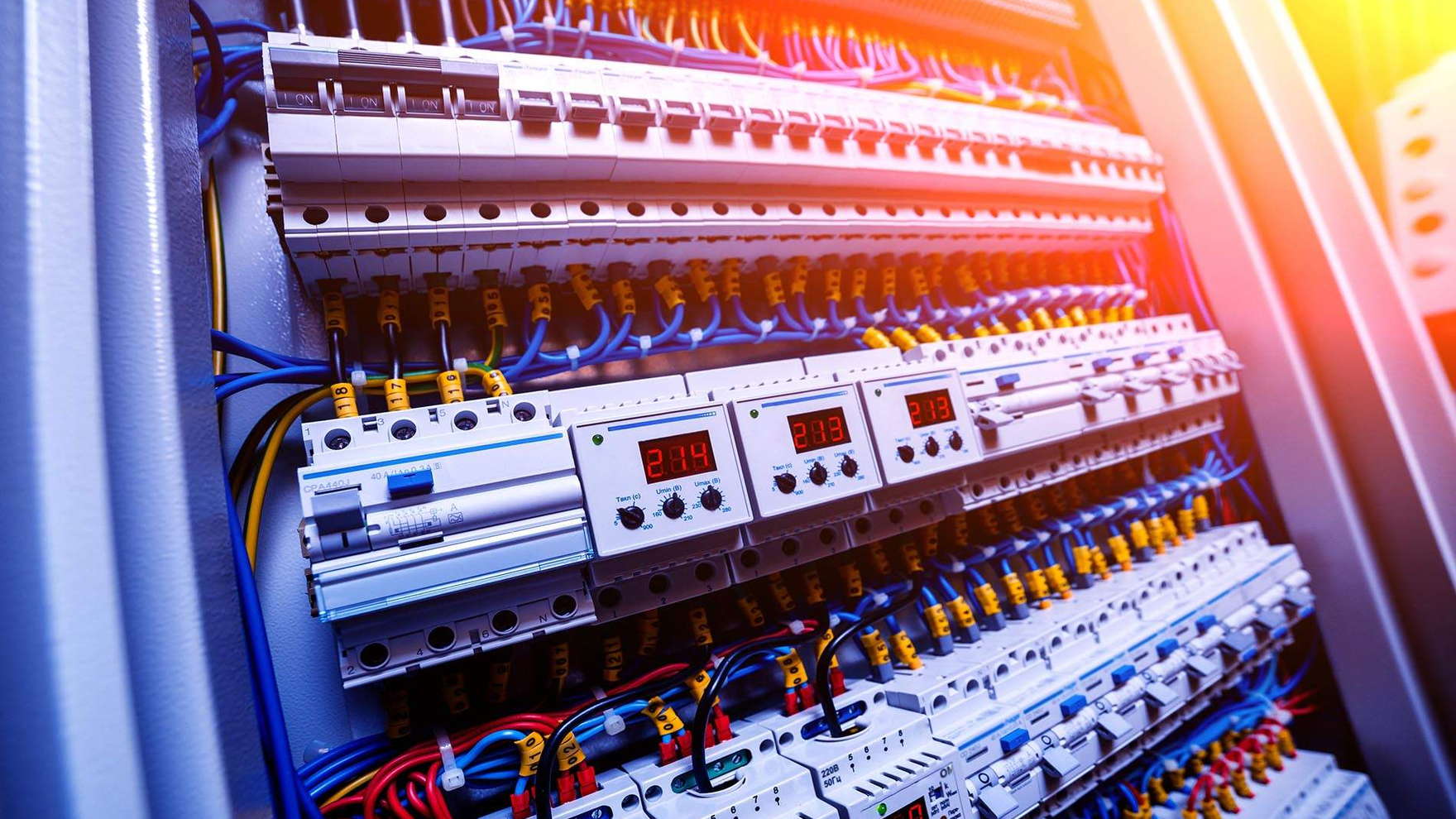 Rows of circuit breakers and coloured wiring inside an open switchboard